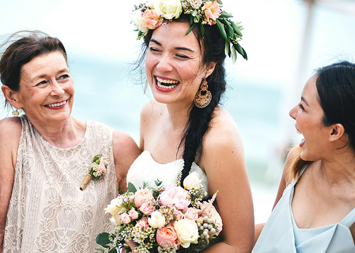 Women laughing joyfully at a beach wedding, highlighting boundaries with money and bachelorette costs. Women laughing joyfully at a beach wedding, highlighting boundaries with money and bachelorette costs.