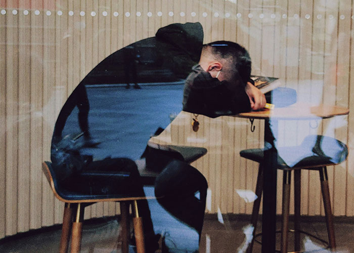 Person sitting at a desk, head down, pondering money boundaries and bachelorette costs. Person sitting at a desk, head down, pondering money boundaries and bachelorette costs.