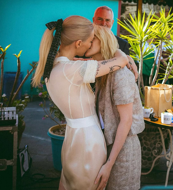 Lovebirds sharing a tender moment in an intimate wedding setting with vibrant outdoor decor. Lovebirds sharing a tender moment in an intimate wedding setting with vibrant outdoor decor.