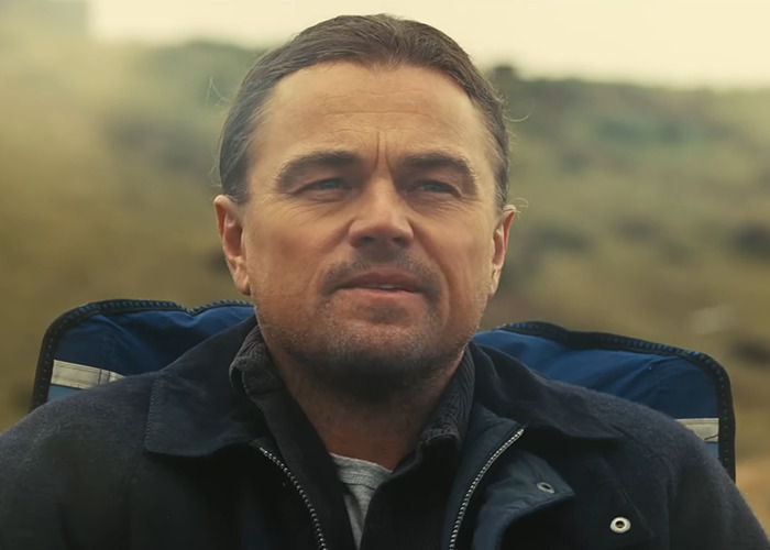 Man outdoors with slicked-back hair, wearing a navy jacket, suggesting a new look. Man outdoors with slicked-back hair, wearing a navy jacket, suggesting a new look.