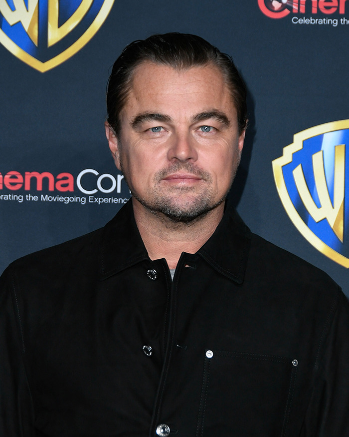 Man in a black jacket at a red carpet event in front of a branded backdrop, showcasing a midlife change. Man in a black jacket at a red carpet event in front of a branded backdrop, showcasing a midlife change.