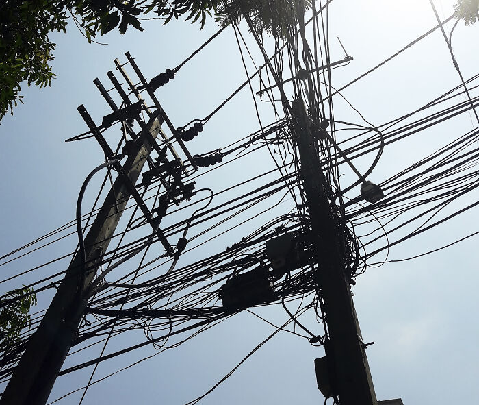 Overhead power lines and transformers silhouetted against sky, symbolizing major blackout impacting 50M Europeans and disrupting activities. Overhead power lines and transformers silhouetted against sky, symbolizing major blackout impacting 50M Europeans and disrupting activities.
