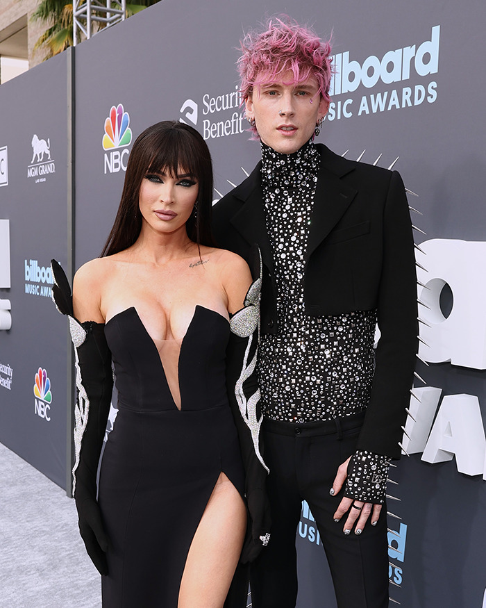 Machine Gun Kelly and Megan Fox at an event, posing on the red carpet in glamorous attire. Machine Gun Kelly and Megan Fox at an event, posing on the red carpet in glamorous attire.