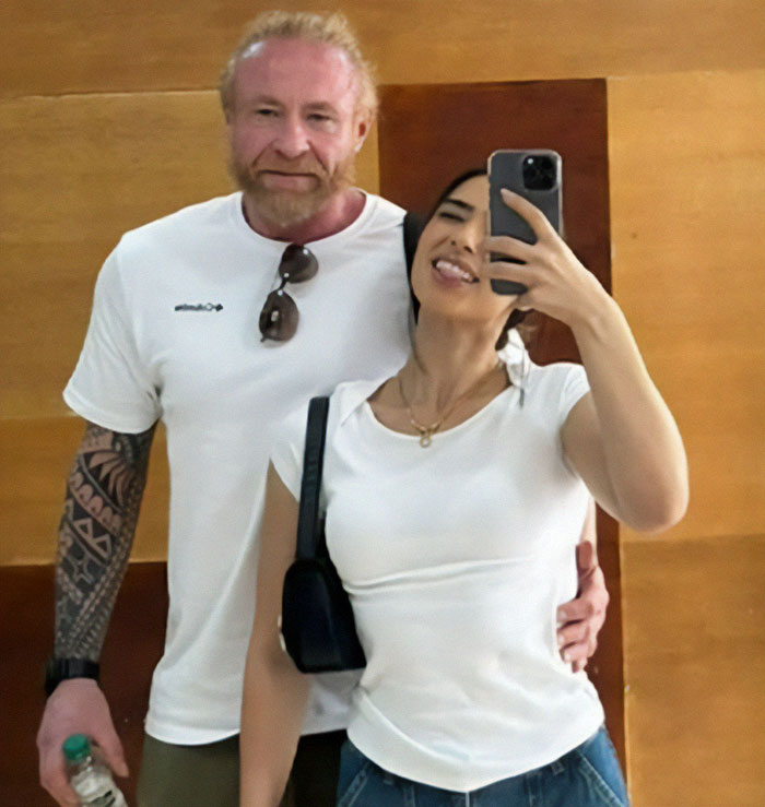 Man on vacation with wife, both smiling, capturing a selfie together. Man on vacation with wife, both smiling, capturing a selfie together.