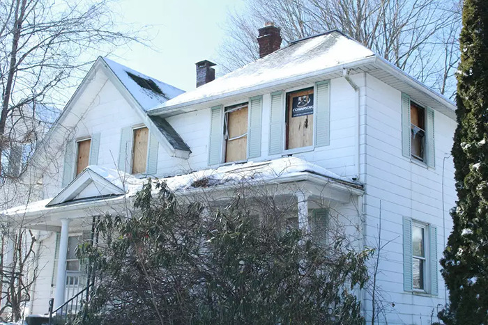 Abandoned house with boarded windows in winter, related to a man's story of captivity by stepmom. Abandoned house with boarded windows in winter, related to a man's story of captivity by stepmom.