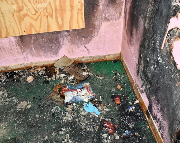 Damaged room showing evidence of long-term captivity, with debris and burned items on the floor. Damaged room showing evidence of long-term captivity, with debris and burned items on the floor.