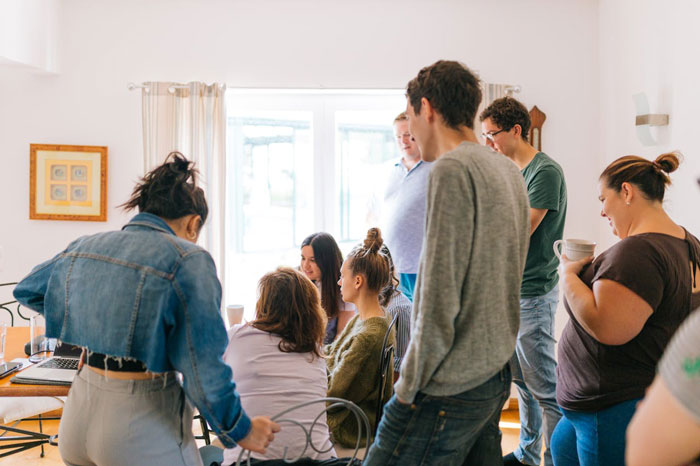 Group of friends gathered in a living room, with a laptop visible, discussing a personal matter. Group of friends gathered in a living room, with a laptop visible, discussing a personal matter.