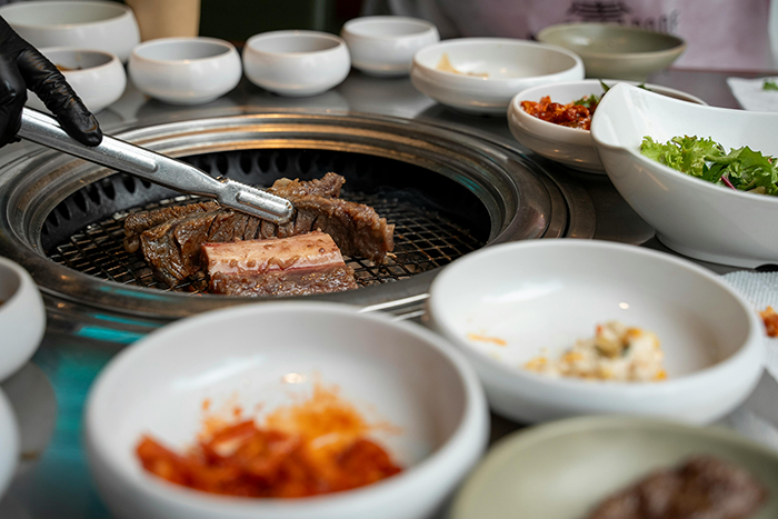 Barbecue setting with grilled meat and side dishes, highlighting coworker exclusion due to diet. Barbecue setting with grilled meat and side dishes, highlighting coworker exclusion due to diet.