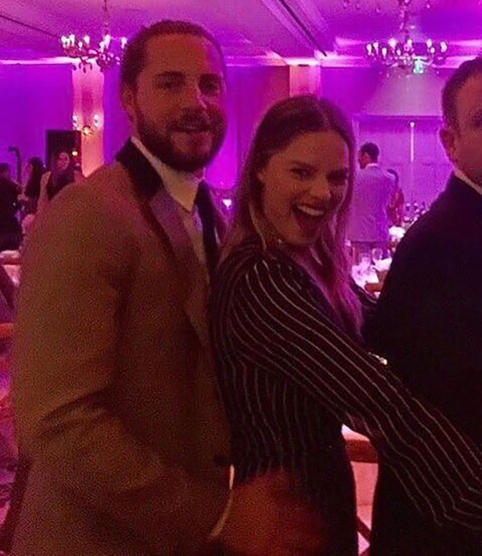 A woman in a striped outfit at a vibrant party, showcasing her postpartum body with confidence. A woman in a striped outfit at a vibrant party, showcasing her postpartum body with confidence.