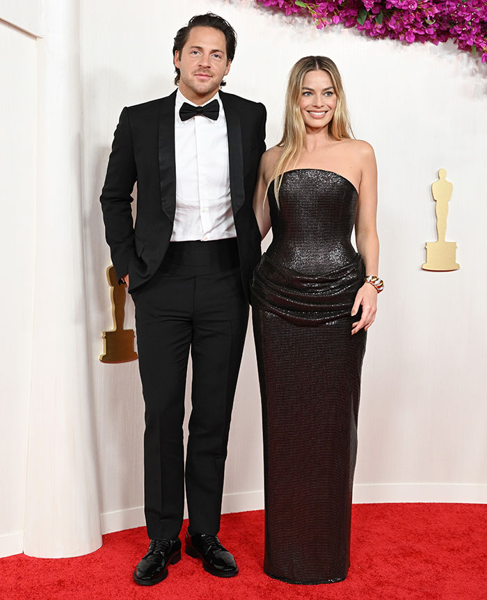 Woman in a black strapless dress on the red carpet, showcasing postpartum body confidence. Woman in a black strapless dress on the red carpet, showcasing postpartum body confidence.