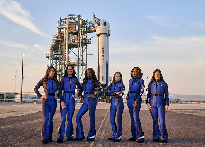 Women in Blue Origin suits pose confidently in front of a rocket launchpad, embodying modern astronauts. Women in Blue Origin suits pose confidently in front of a rocket launchpad, embodying modern astronauts.