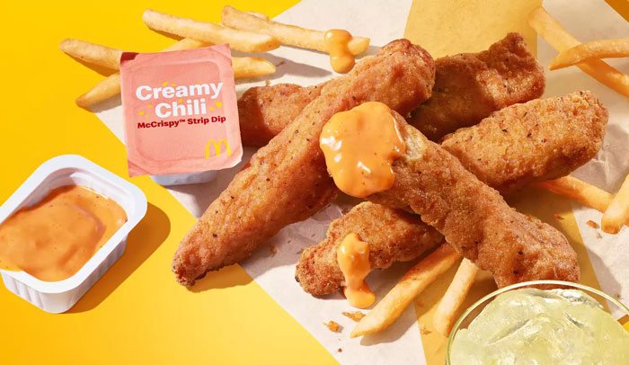 McDonald's chicken strips with fries and creamy chili dip on a yellow background.