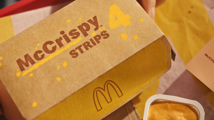 McDonald's McCrispy Chicken Strips box with sauce, highlighting their return. McDonald's McCrispy Chicken Strips box with sauce, highlighting their return.