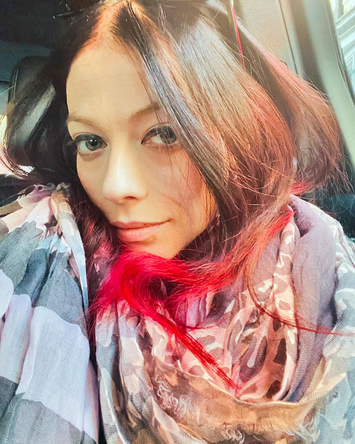 I'm not sure who this is. The person has long brown hair with red highlights, wearing a patterned scarf in a close-up portrait. I'm not sure who this is. The person has long brown hair with red highlights, wearing a patterned scarf in a close-up portrait.