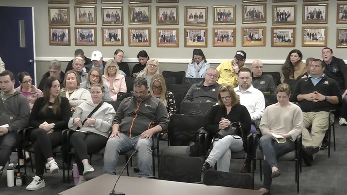 Parents at a meeting reacting to a middle school survey controversy. Parents at a meeting reacting to a middle school survey controversy.