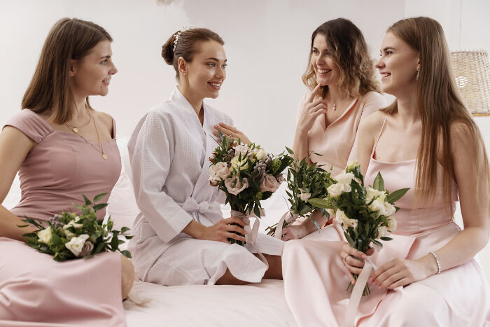 Bride and bridesmaids holding bouquets and smiling, reflecting on the joy of weddings and new generation trends. Bride and bridesmaids holding bouquets and smiling, reflecting on the joy of weddings and new generation trends.