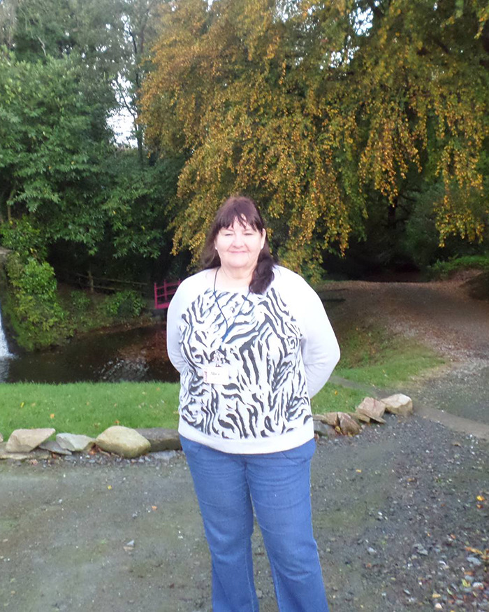 Woman standing outdoors in park, wearing a zebra-print shirt and jeans, related to baby case. Woman standing outdoors in park, wearing a zebra-print shirt and jeans, related to baby case.
