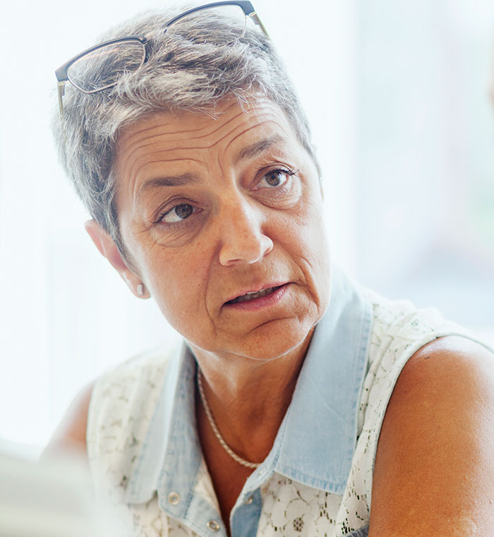 Elderly woman with short gray hair and glasses, contemplating financial planning for her parents' apartment share. Elderly woman with short gray hair and glasses, contemplating financial planning for her parents' apartment share.