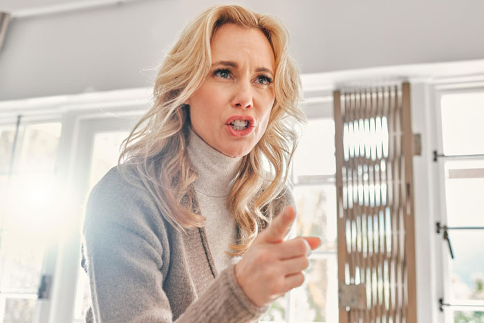 Woman in a turtleneck, appearing firm and expressive, discussing moral grounds and inheritance decisions in a bright room. Woman in a turtleneck, appearing firm and expressive, discussing moral grounds and inheritance decisions in a bright room.