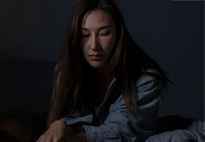 A woman in dark lighting, reflecting solemnly, highlighting work-life balance challenges during maternity leave. A woman in dark lighting, reflecting solemnly, highlighting work-life balance challenges during maternity leave.