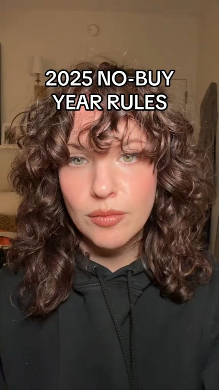 Person discussing No-Buy 2025 rules with curly hair and a black hoodie, emphasizing reduced consumerism. Person discussing No-Buy 2025 rules with curly hair and a black hoodie, emphasizing reduced consumerism.