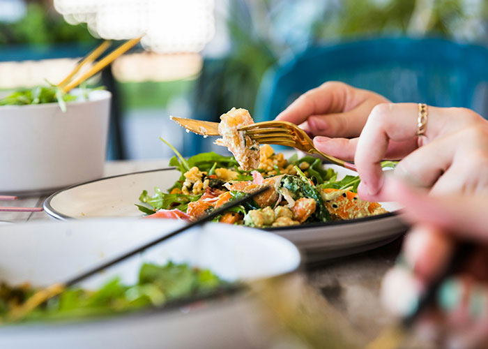 Hands holding forks, eating a colorful vegetarian dish, highlighting wedding meal options without meat. Hands holding forks, eating a colorful vegetarian dish, highlighting wedding meal options without meat.