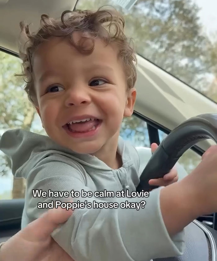 Smiling child in car, wearing a hoodie, with text overlay. Smiling child in car, wearing a hoodie, with text overlay.