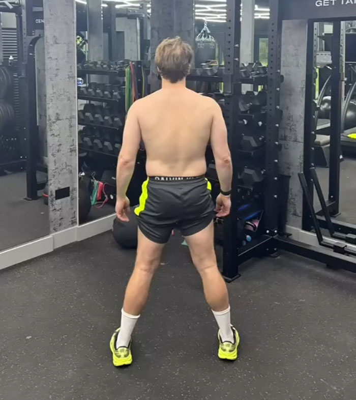 Man in gym wearing shorts and sneakers, showing physique transformation sparking debate between men and women. Man in gym wearing shorts and sneakers, showing physique transformation sparking debate between men and women.