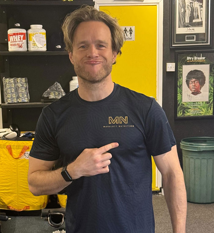 Singer in a gym pointing at his physique transformation, sparking a heated debate between men and women. Singer in a gym pointing at his physique transformation, sparking a heated debate between men and women.