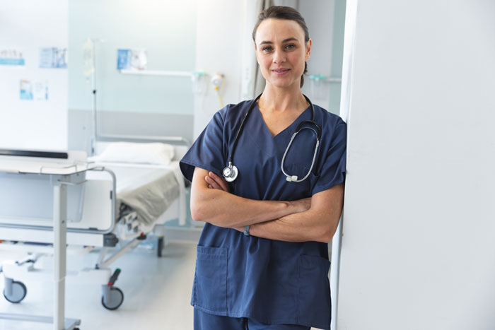 Nurse standing confidently in a hospital room, ready to assist patients with professional care. Nurse standing confidently in a hospital room, ready to assist patients with professional care.