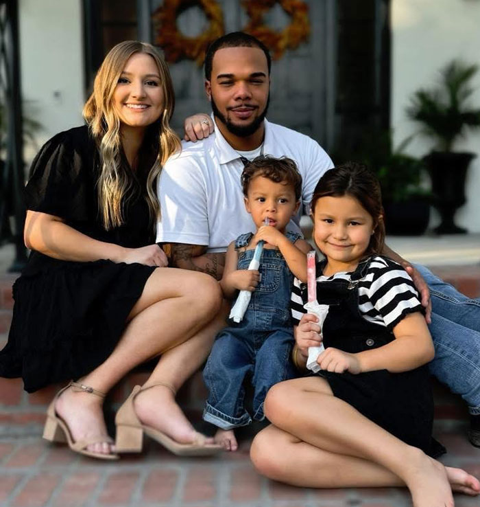 A family on steps, smiling together. Young boy, known as 'Okay Baby,' holds a popsicle, remembered fondly. A family on steps, smiling together. Young boy, known as 'Okay Baby,' holds a popsicle, remembered fondly.