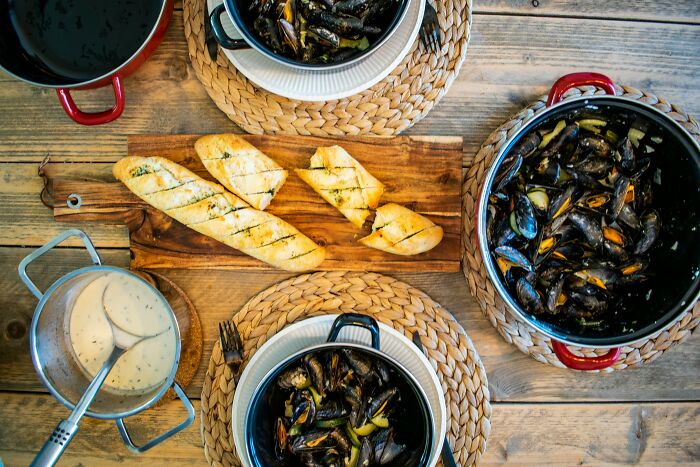 Mussels served with baguette on a rustic table, representing a top dish from different countries.