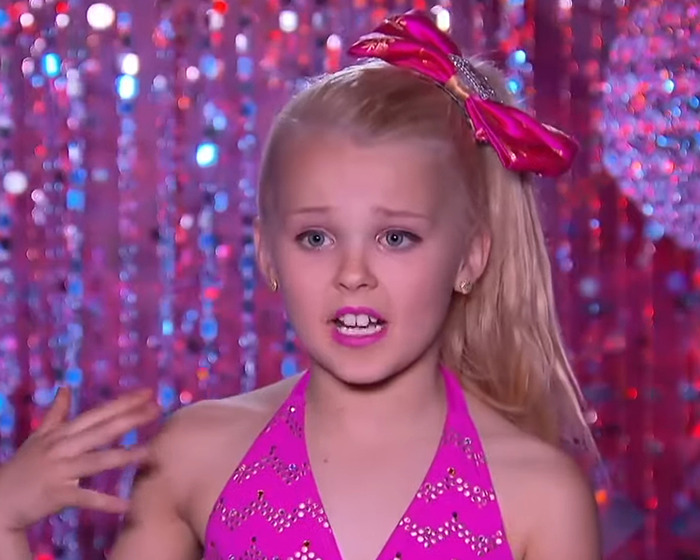 Young dancer in a pink outfit with a bow, performing on 'Dance Moms,' amidst a brewing Big Brother controversy. Young dancer in a pink outfit with a bow, performing on 'Dance Moms,' amidst a brewing Big Brother controversy.