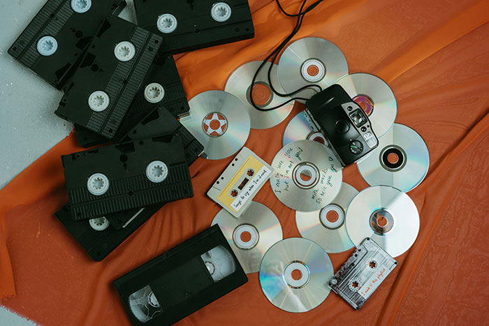 VHS tapes, CDs, cassette tapes, and a camera highlight the enduring appeal of physical media on a vibrant background. VHS tapes, CDs, cassette tapes, and a camera highlight the enduring appeal of physical media on a vibrant background.