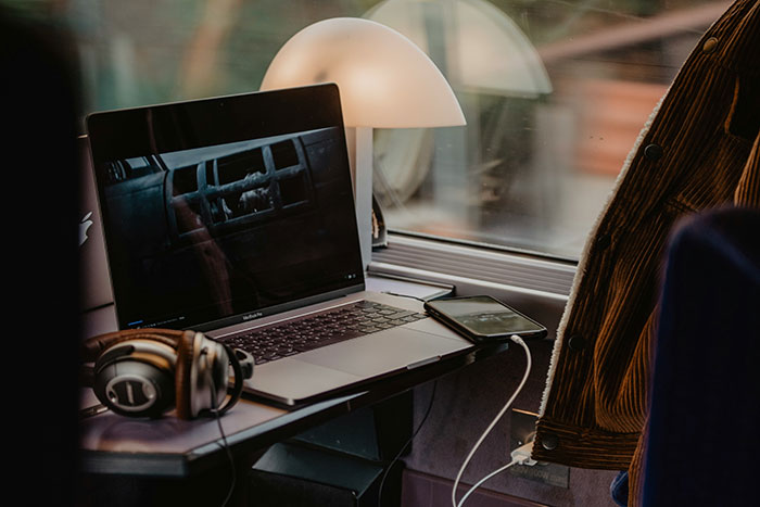 Laptop and headphones on a train table, showcasing physical media magic in a cozy travel setting. Laptop and headphones on a train table, showcasing physical media magic in a cozy travel setting.