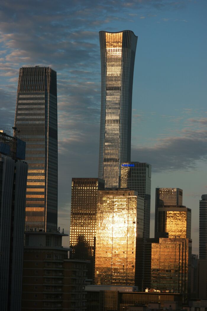 Sunset view of the skyline featuring some of the world's tallest buildings, reflecting golden light in a cityscape.