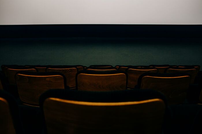 Empty movie theater with rows of seats facing a blank screen, ready for viewers to recognize characters. Empty movie theater with rows of seats facing a blank screen, ready for viewers to recognize characters.