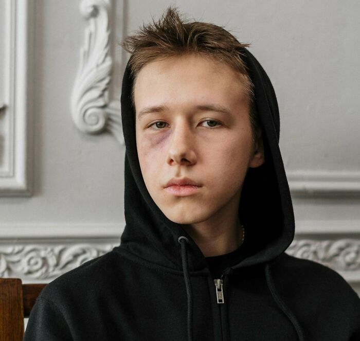 Young person in a hoodie with a serious expression, embodying the essence of being fooled on April 1st.
