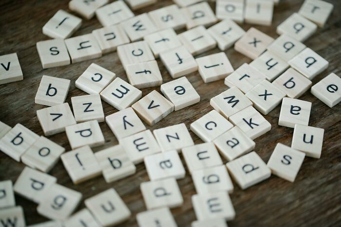 Wooden letter tiles scattered on a table representing unusual words and fluency in nonsense vocabulary.