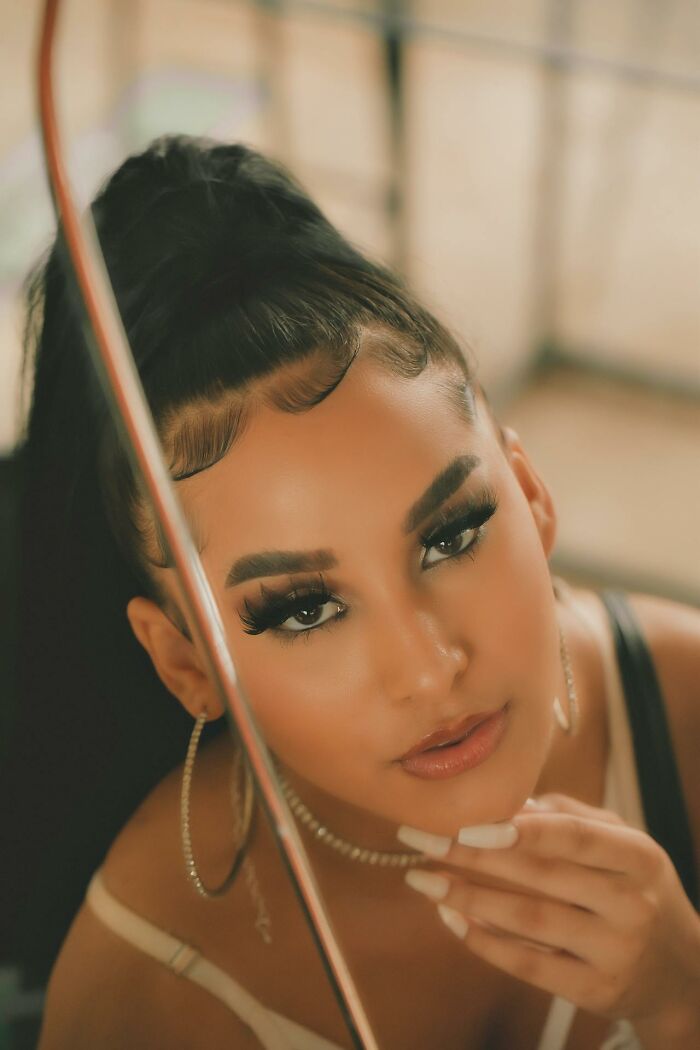 Woman with bold makeup looking at reflection, showcasing an aspect of embarrassment that confuses men.