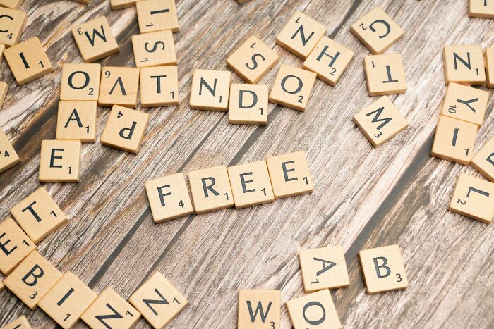 Scattered wooden letter tiles on a wooden surface with the word free spelled out, perfect for word puzzles and scrambles. Scattered wooden letter tiles on a wooden surface with the word free spelled out, perfect for word puzzles and scrambles.