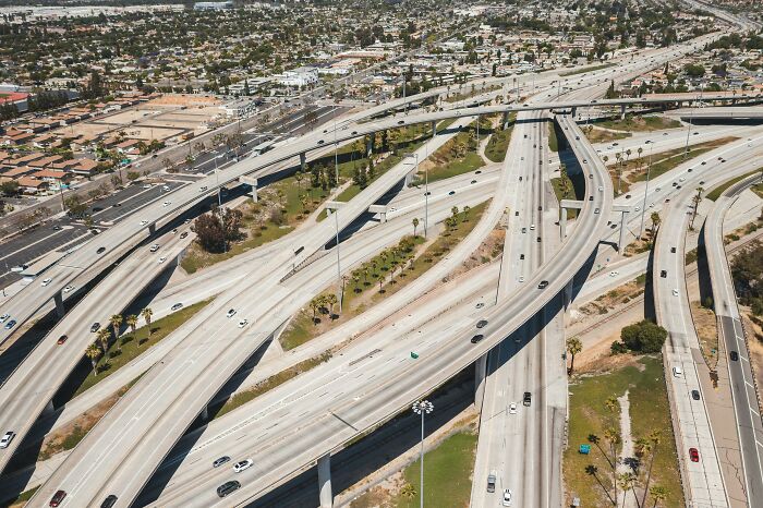 American highway overpass with multiple lanes and interchanges, showcasing complex road design seen from above.