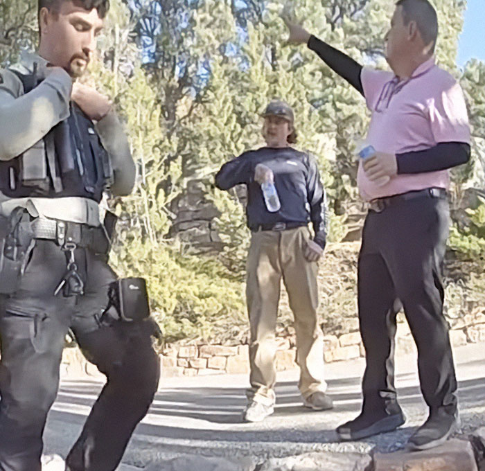 Police and two men discussing outside, referencing Gene Hackman's dog related incident in a wooded area. Police and two men discussing outside, referencing Gene Hackman's dog related incident in a wooded area.