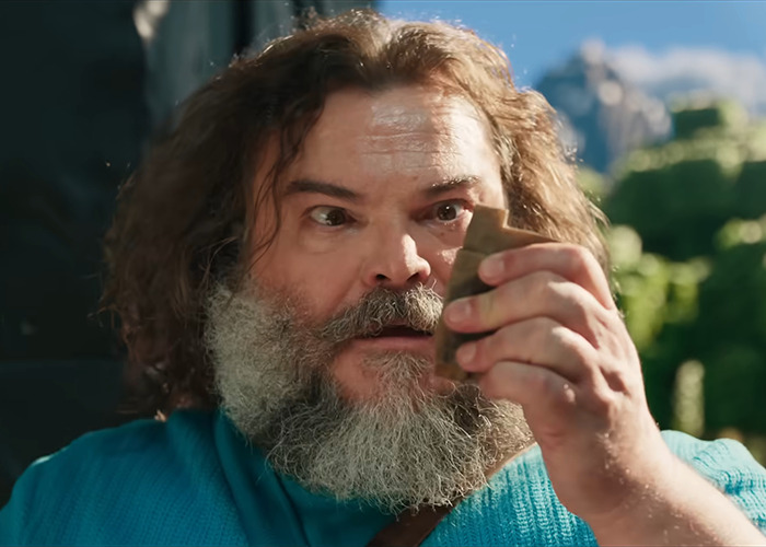 Man holding an object outdoors, reacting with surprise, related to 'A Minecraft Movie'. Man holding an object outdoors, reacting with surprise, related to 'A Minecraft Movie'.