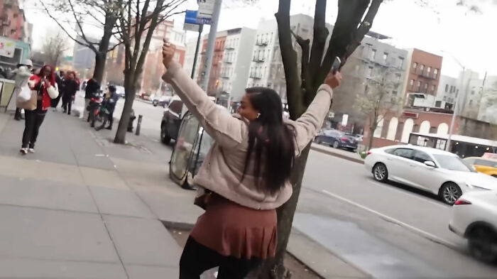 A woman gestures on a city sidewalk during an abortion street interview, with cars and buildings in the background. A woman gestures on a city sidewalk during an abortion street interview, with cars and buildings in the background.