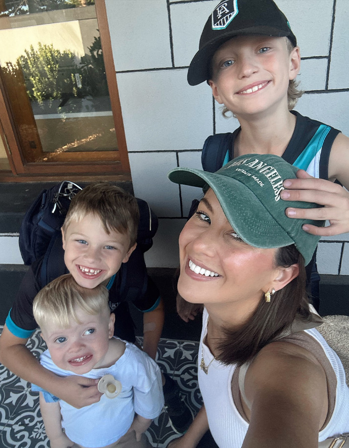 Woman with three children smiling outside, wearing casual hats; related to a restaurant incident with a toddler. Woman with three children smiling outside, wearing casual hats; related to a restaurant incident with a toddler.