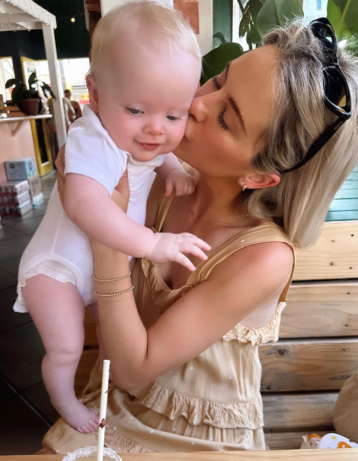 Mother embraces toddler in a restaurant setting, reflecting on a recent parenting incident. Mother embraces toddler in a restaurant setting, reflecting on a recent parenting incident.