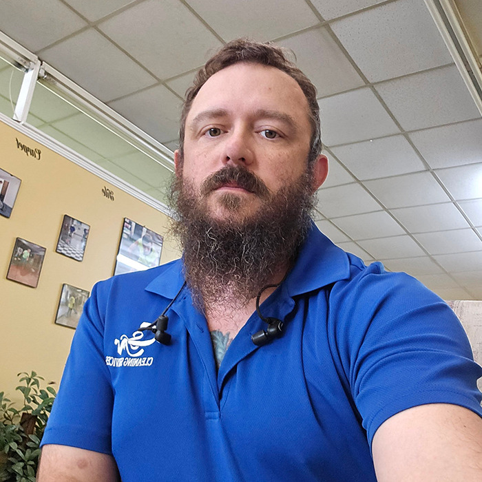 Bearded man in a blue shirt sitting indoors in a restaurant. Bearded man in a blue shirt sitting indoors in a restaurant.