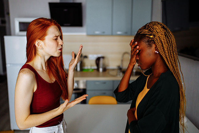 Two women in a kitchen discussing roommate's boyfriend, seeking advice. Two women in a kitchen discussing roommate's boyfriend, seeking advice.