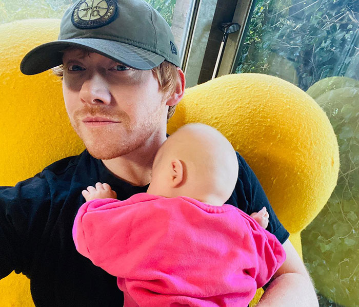 Actor Rupert Grint with his baby daughter in a cozy home setting, displaying new fatherly joy. Actor Rupert Grint with his baby daughter in a cozy home setting, displaying new fatherly joy.